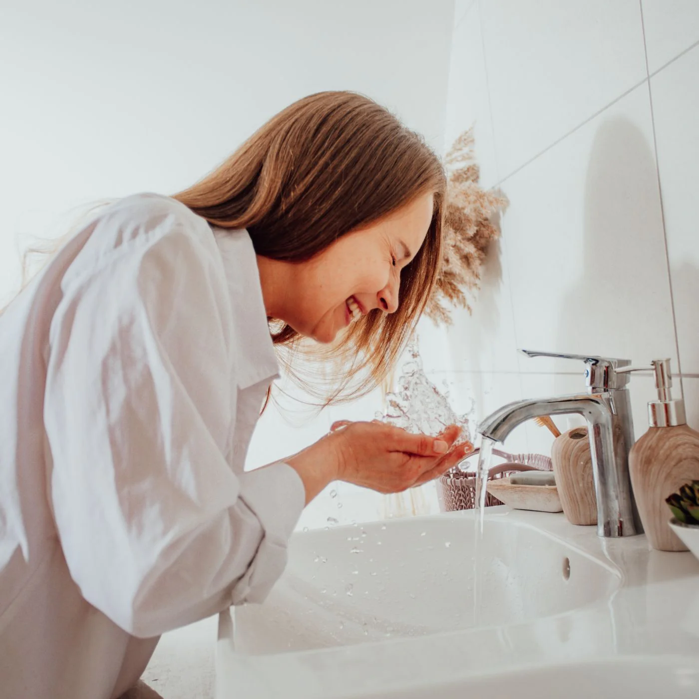 Woman washing her face to hydrate her dry skin